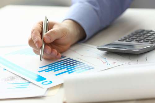 Foto: Person zeigt mit Stift auf Akten